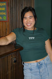 Woman wearing a fitted baby tee embroidered with the number 777.