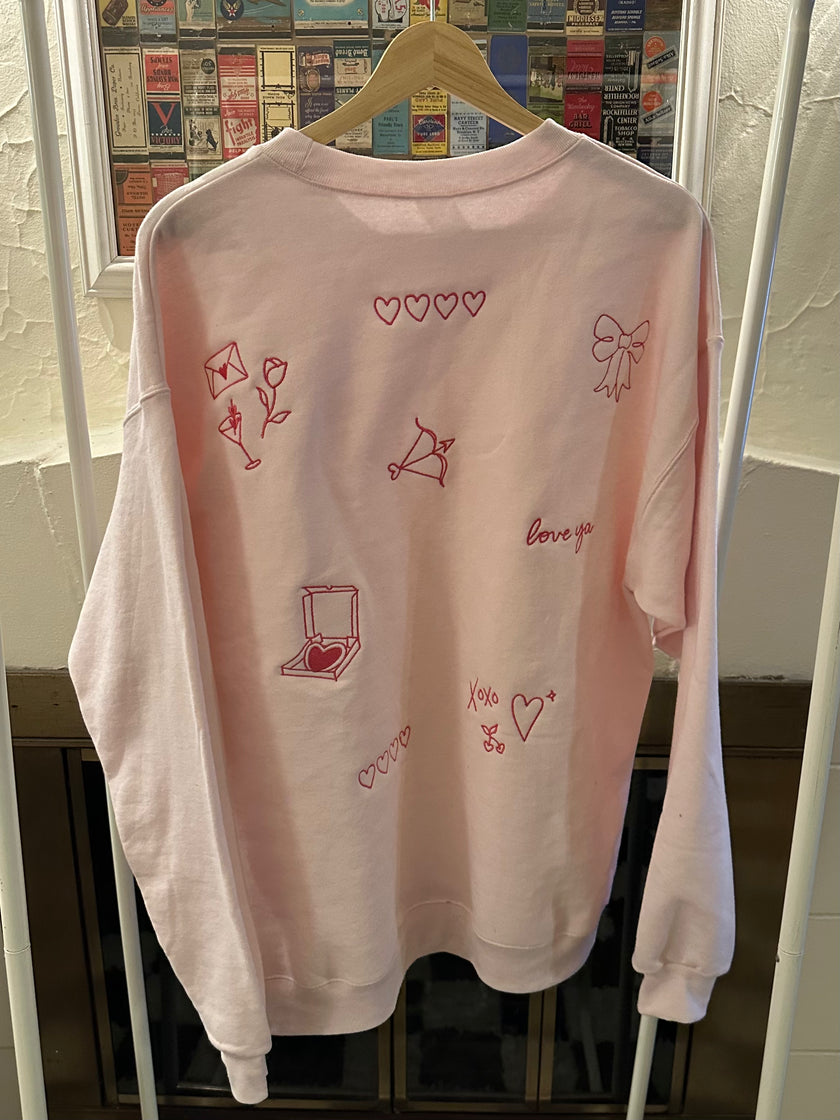 Crewneck sweatshirt featuring an all-over patchwork heart back design.