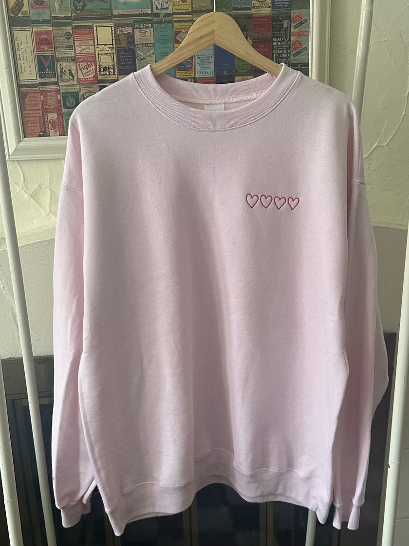 Crewneck sweatshirt featuring an all-over patchwork heart front design.