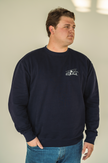 Model wearing the Alpine Inspired embroidered crewneck styled with casual winter layers.