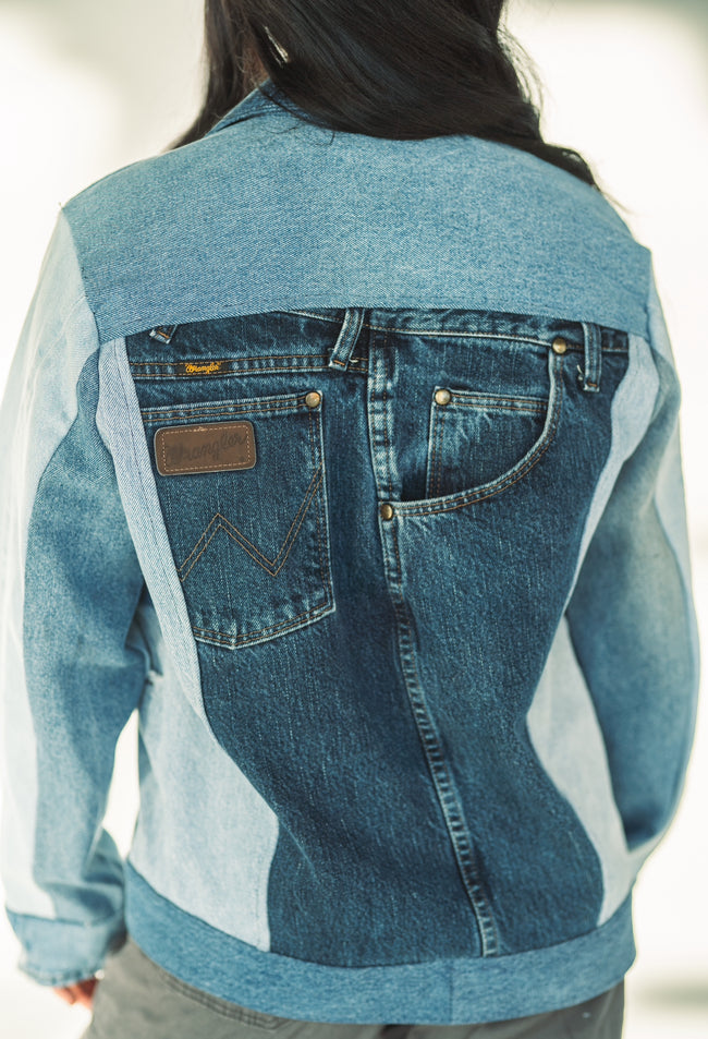 Back view of a one-of-a-kind patchwork denim jacket made from recycled jeans featuring authentic Wrangler pocket details.