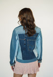 Back view of a one-of-a-kind patchwork denim jacket made from recycled jeans featuring authentic vintage back pocket details.
