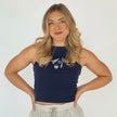 Woman wearing a navy embroidered Columbus hockey tank top featuring a CBUS pennant, hockey stick, puck, and popcorn design.