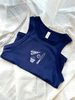 Flat lay of a navy Columbus hockey tank with embroidered game day icons including a CBUS pennant, hockey stick, puck, and popcorn.