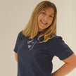 Woman wearing a navy, Comfort Colors Columbus hockey embroidered T-shirt featuring a CBUS pennant, hockey stick, puck, and popcorn design.