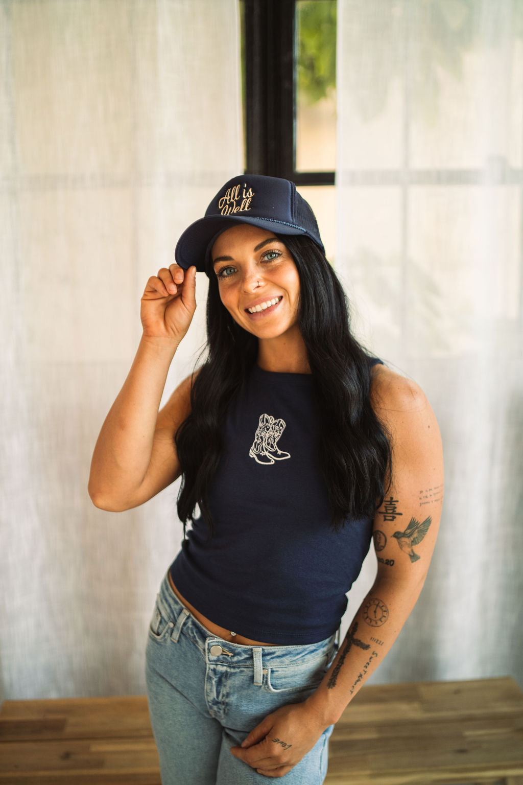 Model wearing a navy embroidered cowgirl boots tank featuring a western-inspired boot design.