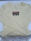 A beige long-sleeve t-shirt with a graphic of four cartoon characters wearing red and black hats spelling 'OHIO' on the chest, laid flat on a white background.