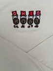 Close-up of a cream-colored fabric garment featuring an embroidered graphic of four cartoon characters holding red signs that spell 'OHIO'.