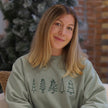 Woman wearing an embroidered Doodle Holiday Trees crewneck sweatshirt featuring whimsical Christmas tree designs.