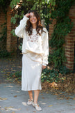 Model wearing an ivory Fall Essentials crewneck sweatshirt styled for a casual yet elevated fall outfit.
