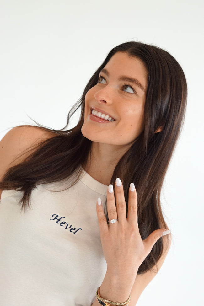 Woman wearing an ivory personalized bridal tank embroidered with a custom future last name in navy script.