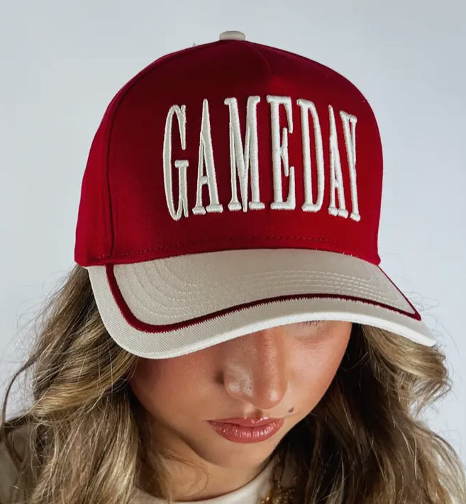 Red and white cap with 'GAMEDAY' text worn by a person