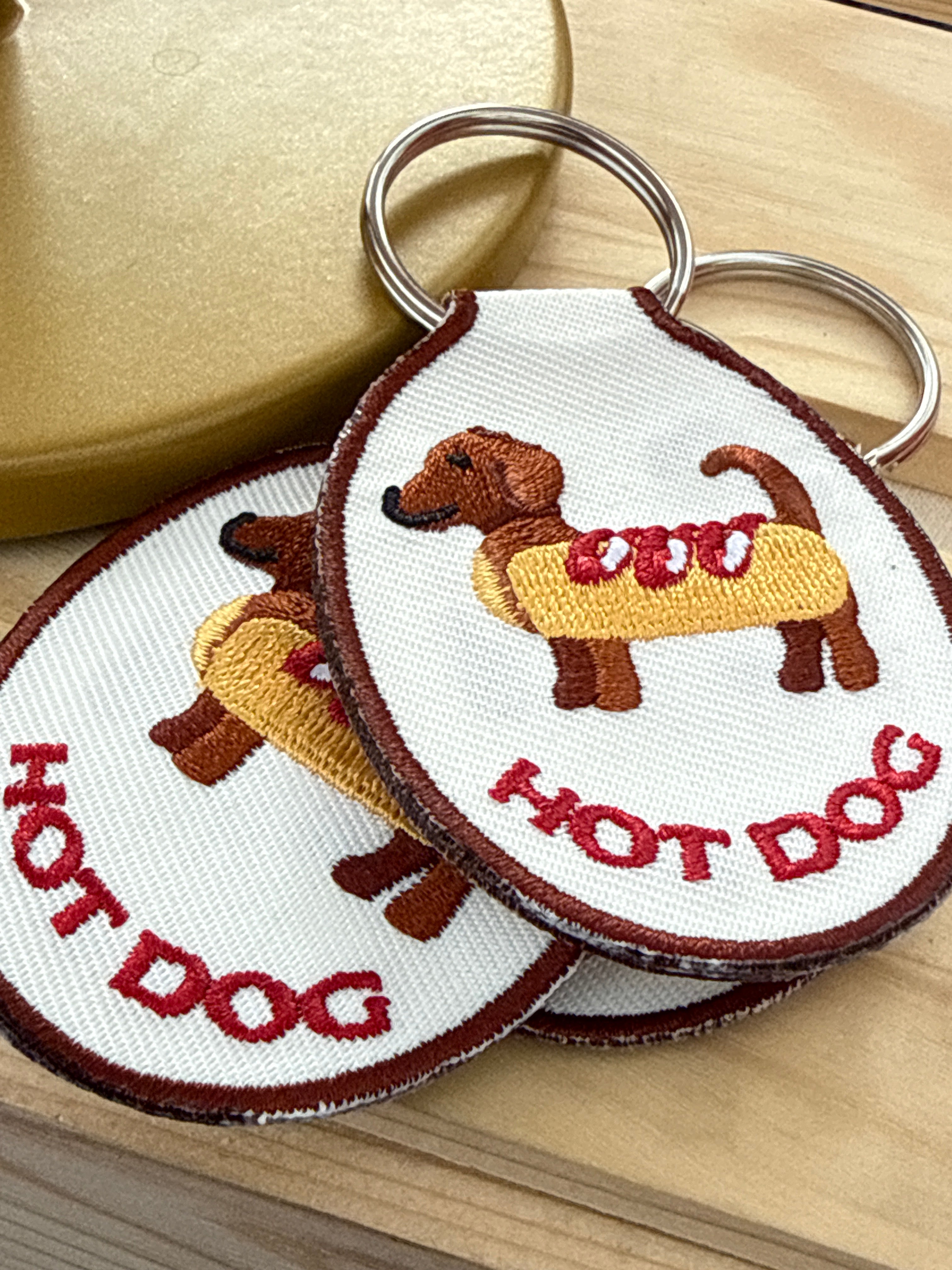 Embroidered hot dog keychain with a gold metal key ring.