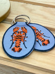 Embroidered lobster keychain with durable key ring.