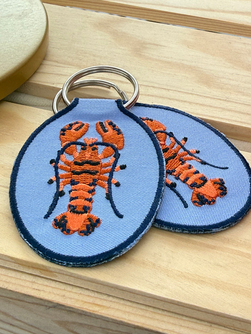 Embroidered lobster keychain with durable key ring.
