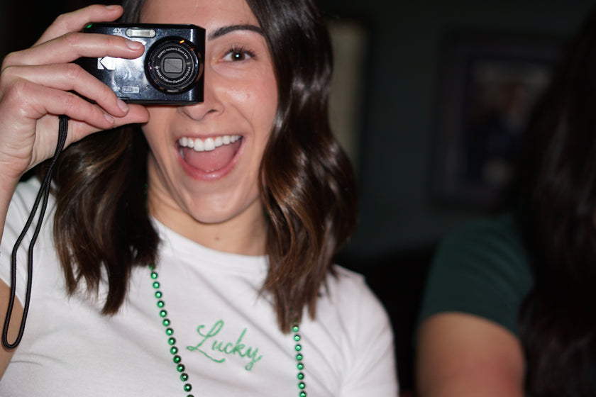 Woman wearing an ivory baby tee embroidered with green 