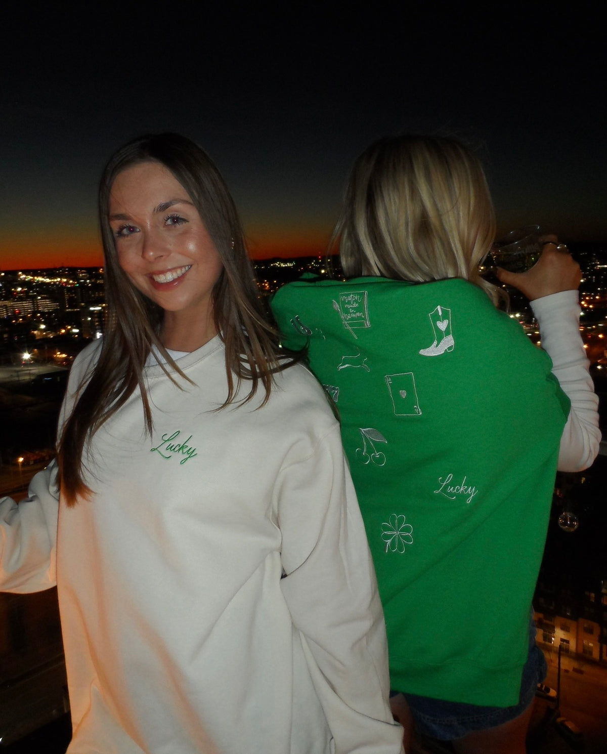 Woman wearing a cream crewneck with green embroidered “Lucky” lettering, styled for a St. Patrick’s Day celebration.