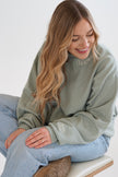 Close-up of a sage green personalized Mama embroidered crewneck sweatshirt featuring custom neckline and sleeve embroidery.