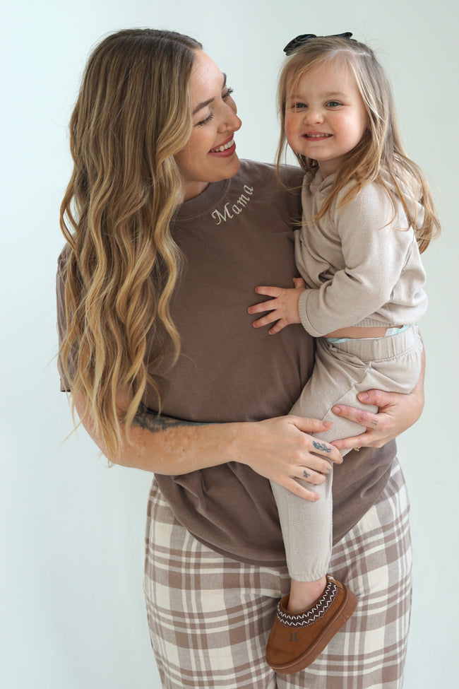 Mom wearing a personalized Mama embroidered T-shirt while holding her young daughter.