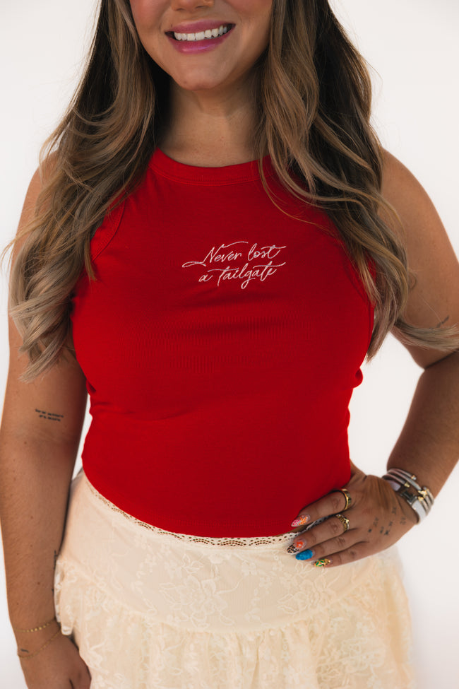 Person wearing a red tank top with text, standing against a white background