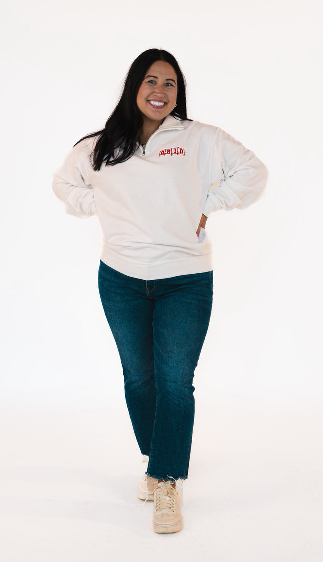 Full View of white quarter zip sweatshirt with red embroidered flags, spelling 