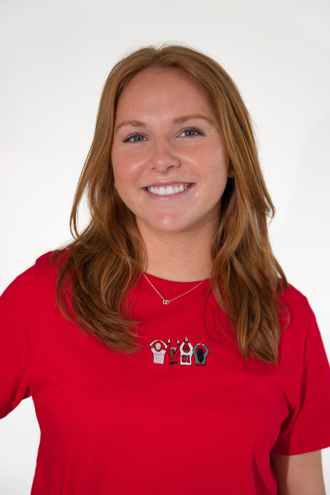 Woman wearing a red short-sleeve T-shirt with an embroidered Ohio-themed graphic on the chest.