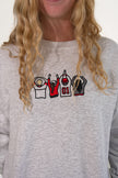 Close-up of a woman wearing a heather gray sweatshirt with an embroidered Ohio-themed graphic on the chest