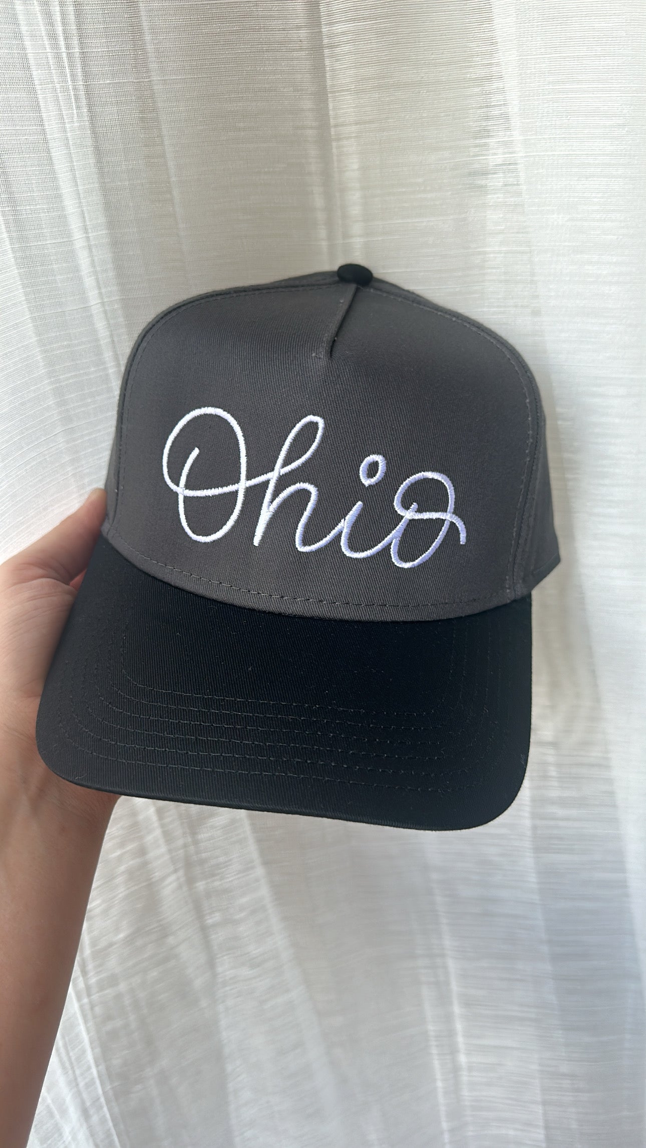 Close-up of the charcoal and black embroidered Ohio design on a structured trucker-style hat.