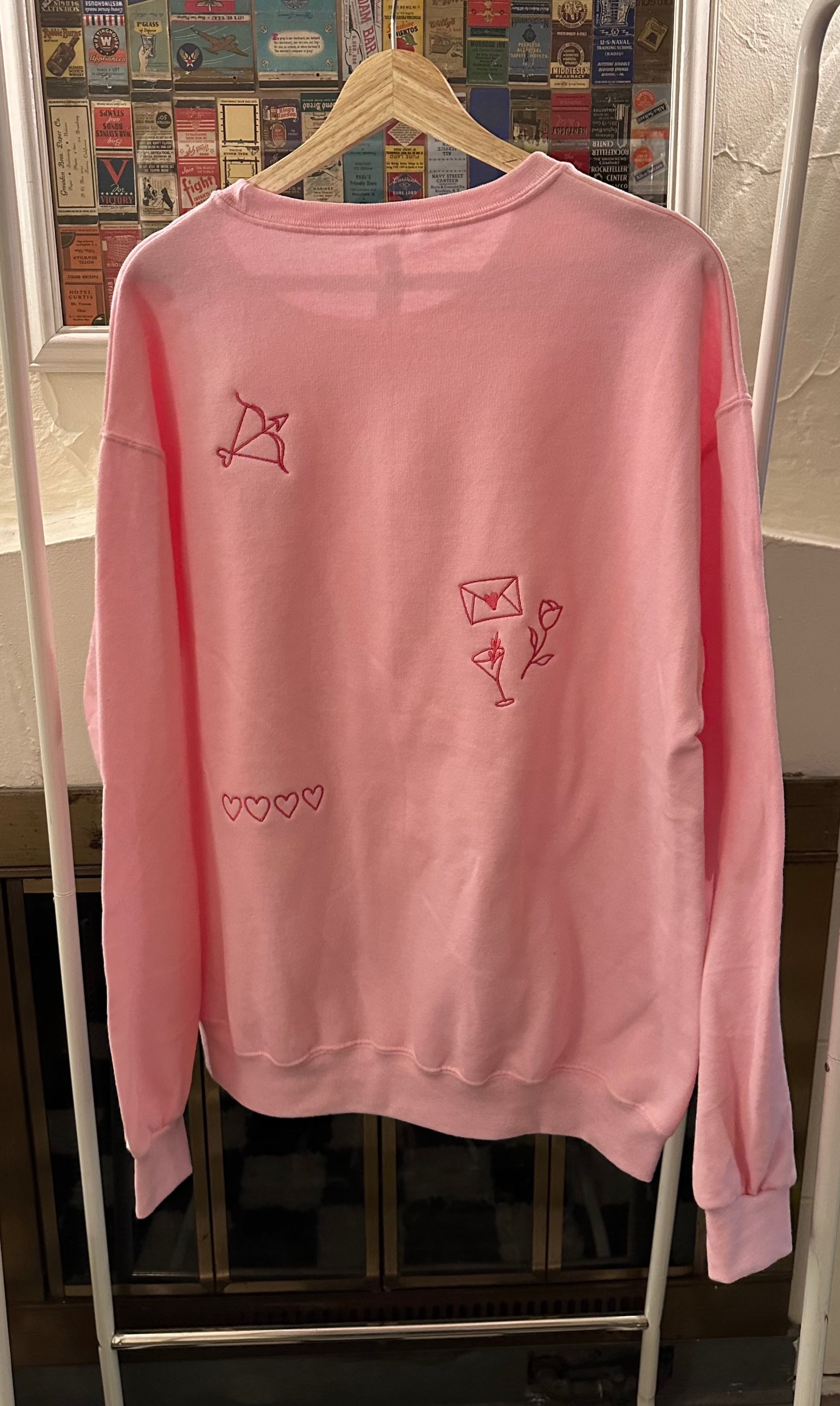 Back view of the light pink embroidered crewneck sweatshirt.