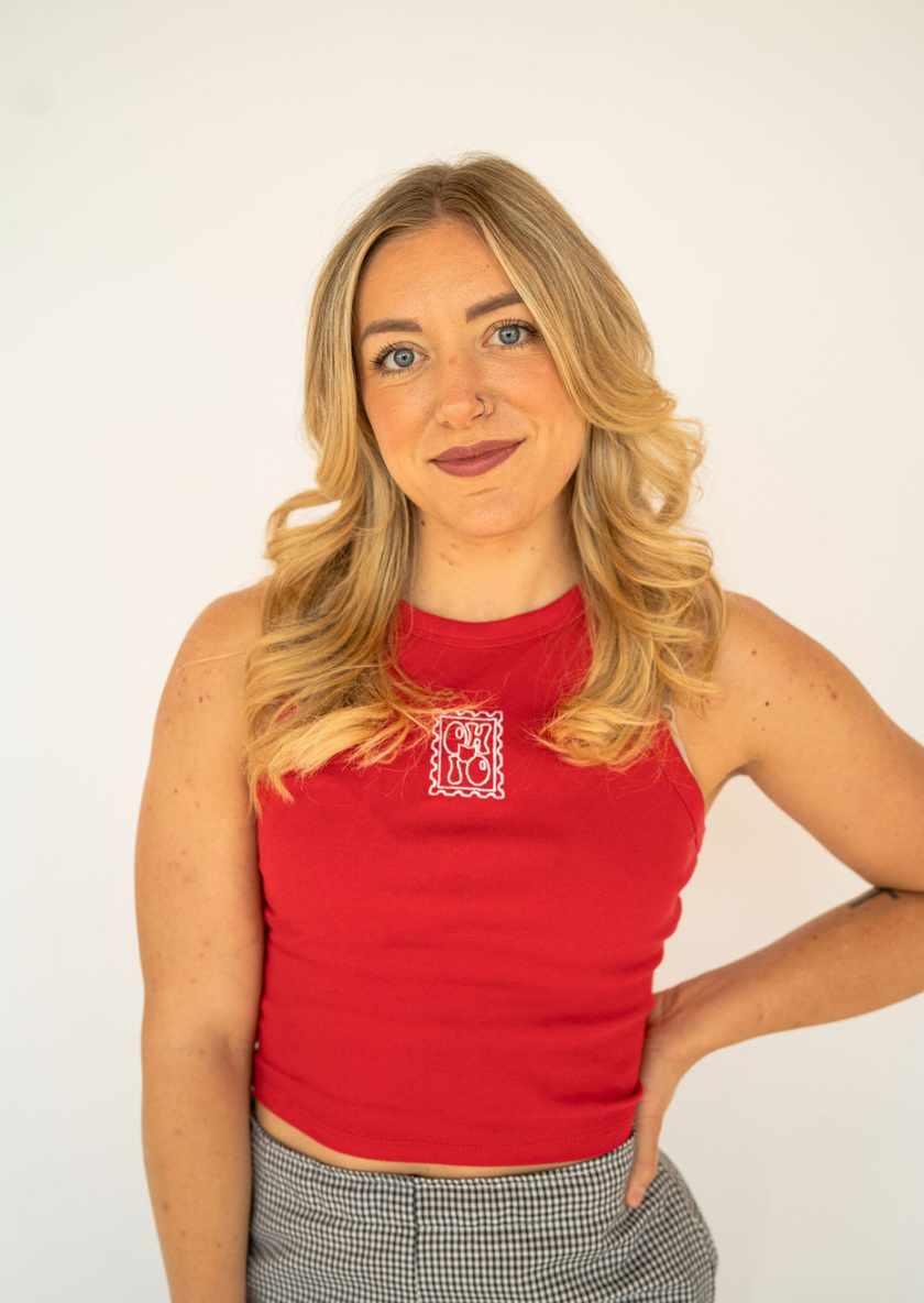 Woman wearing a red fitted tank embroidered with a vintage Ohio postage stamp design.
