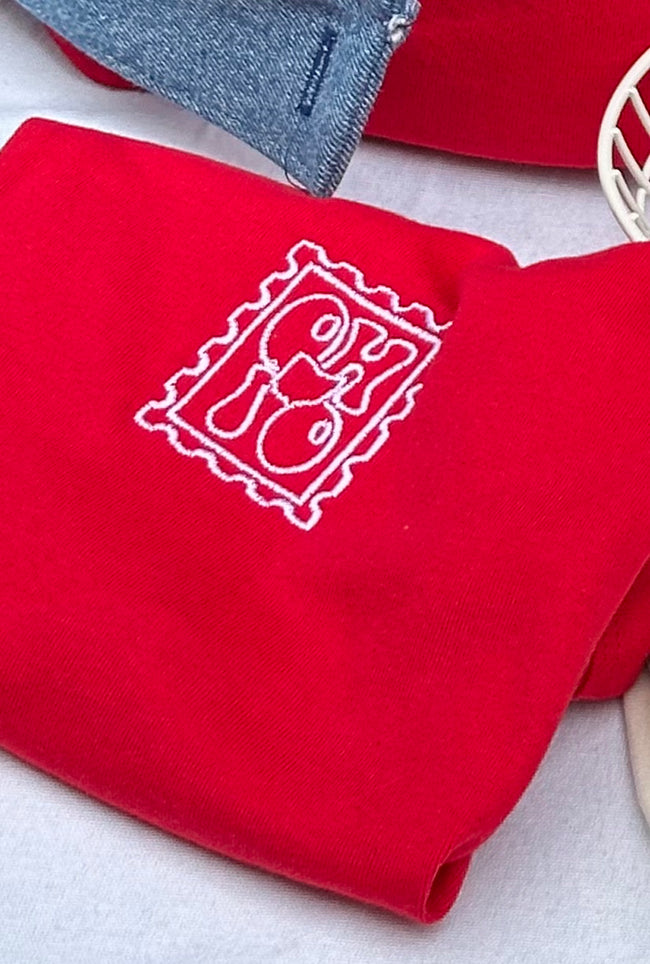 Close-up of a red fitted tank embroidered with a vintage Ohio postage stamp design.