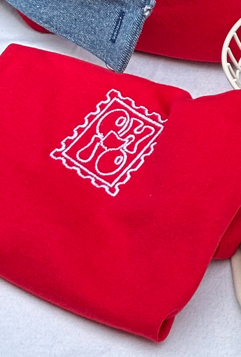 Close-up of a red fitted tank embroidered with a vintage Ohio postage stamp design.