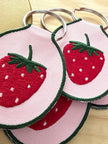 Embroidered strawberry keychain with a gold metal key ring.