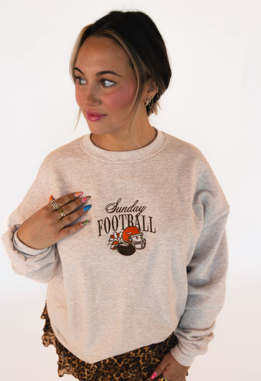 Model wearing a heather gray embroidered Sunday Football crewneck featuring football-inspired graphics for game day.