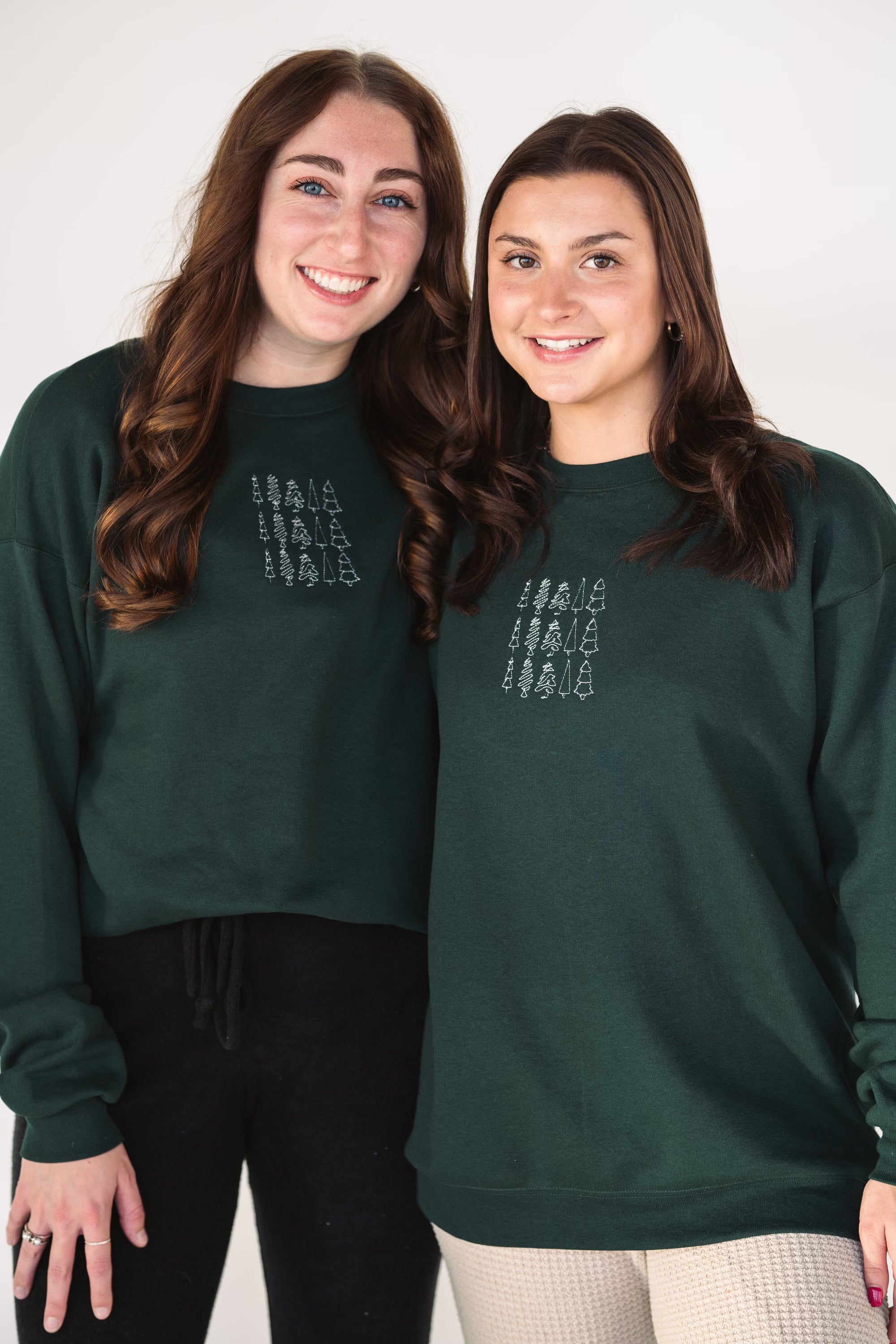 Model wearing the Tri Tree Holiday embroidered crewneck styled for the holiday season.
