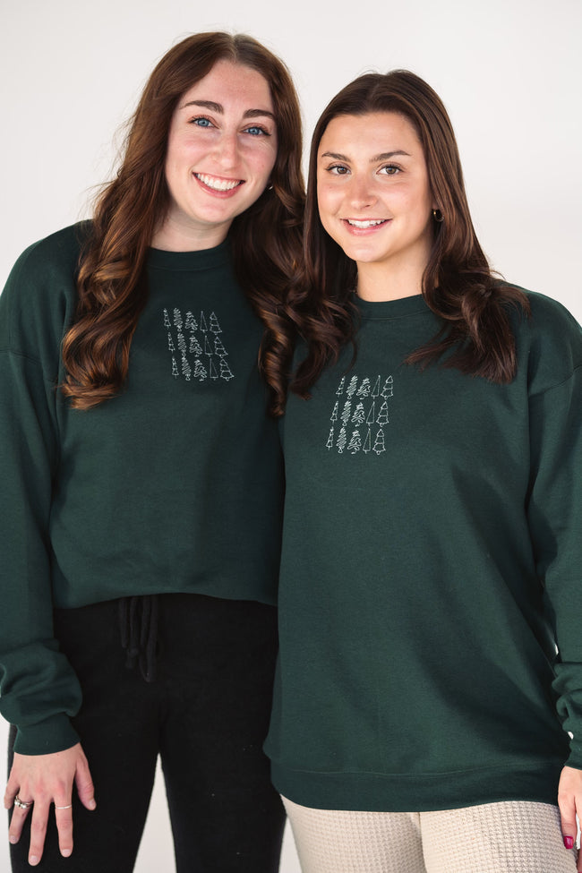 Model wearing the Tri Tree Holiday embroidered crewneck styled for the holiday season.