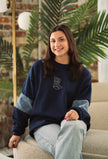 Model wearing the Western Denim Crew sweatshirt styled with casual denim.