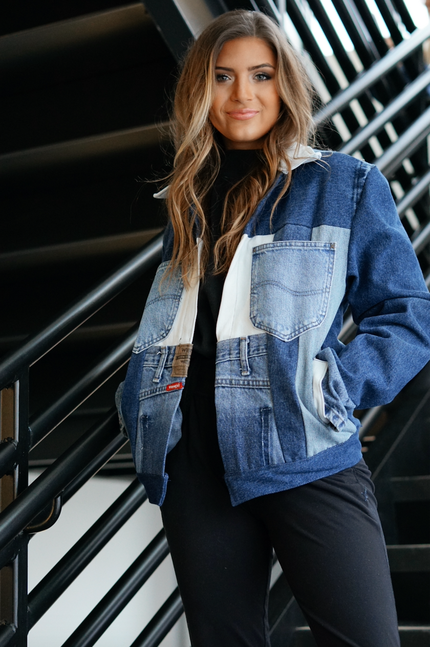 Woman wearing a light wash color-block denim jacket with front patch pockets and oversized fit.